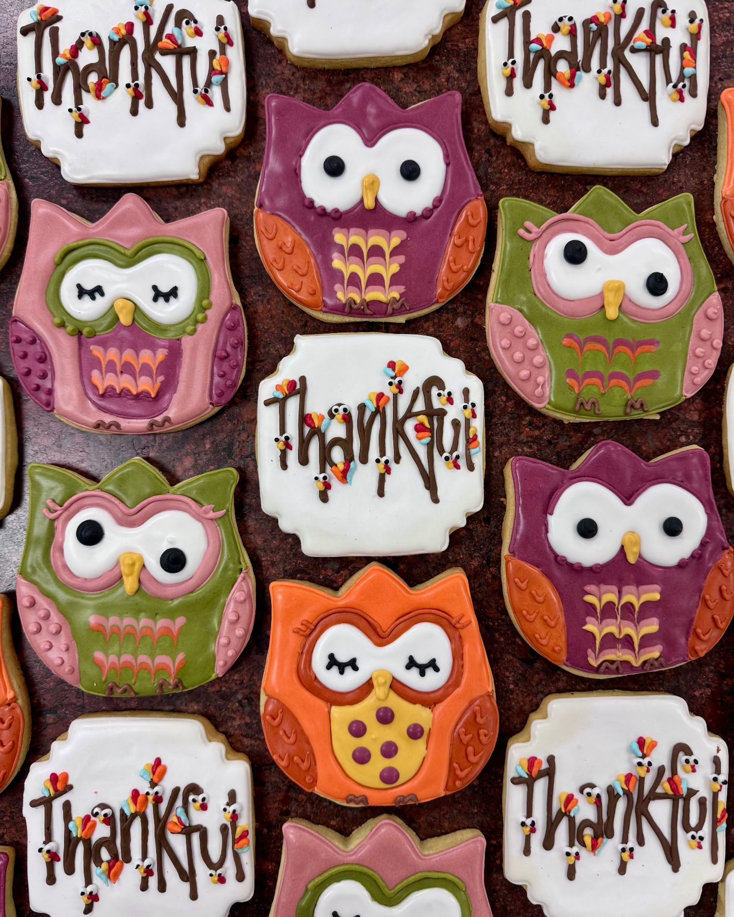 Decorative cookies shaped like owls with 'Thankful' text on a brown background