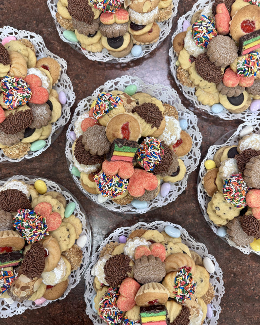 Decorative cookies arranged in circular patterns on a clear tray