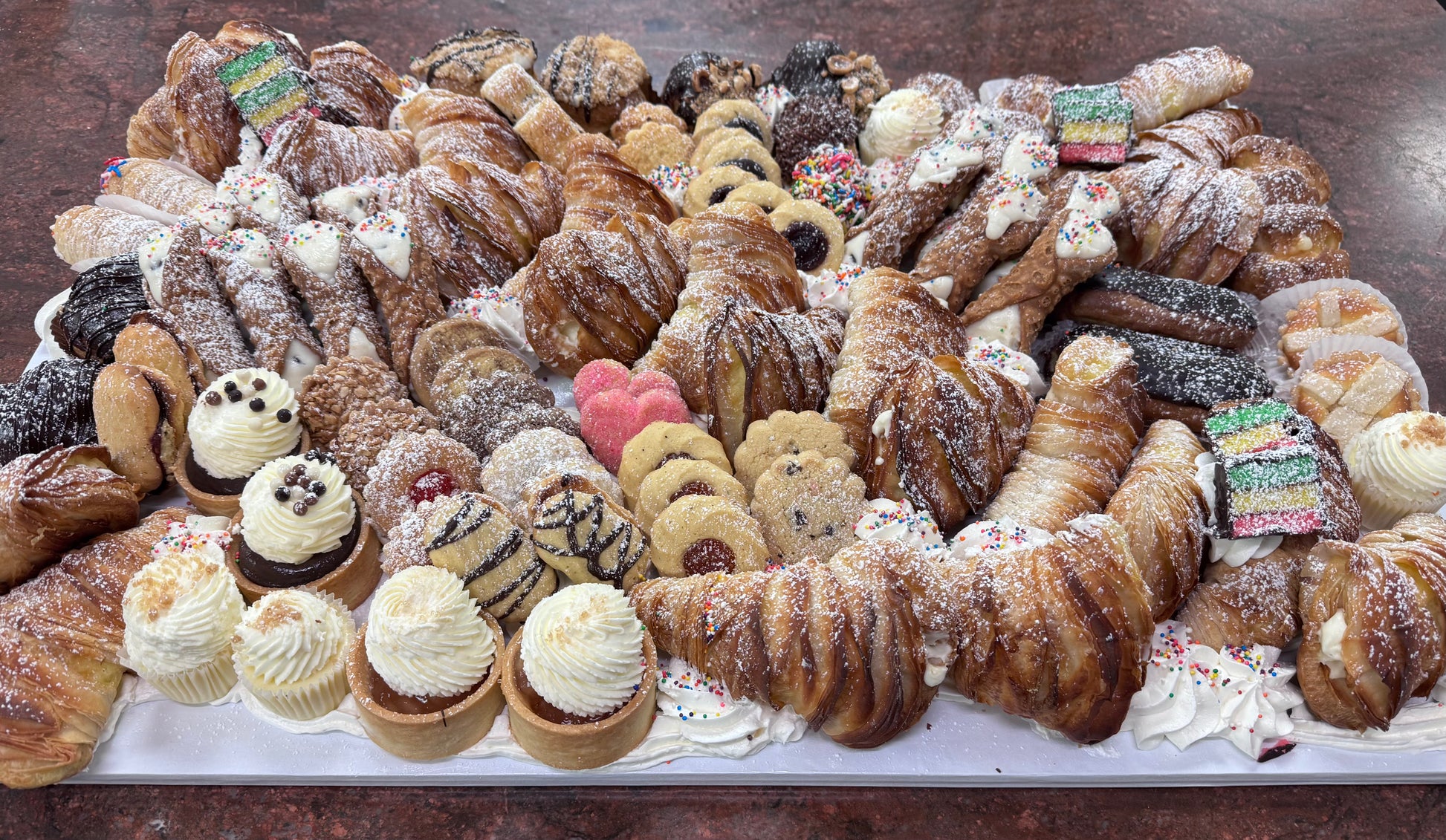Assorted pastries including lobster tails, cookies, and tarts on a tray.