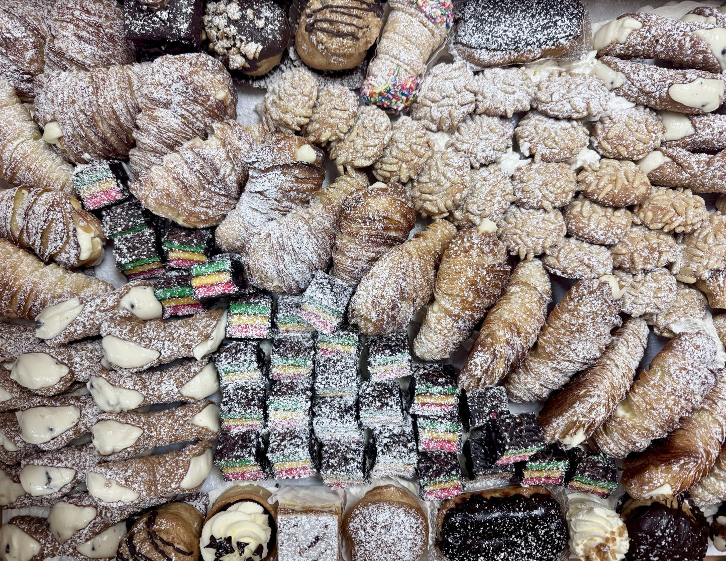 Assorted pastries including lobster tails and cookies on a white plate