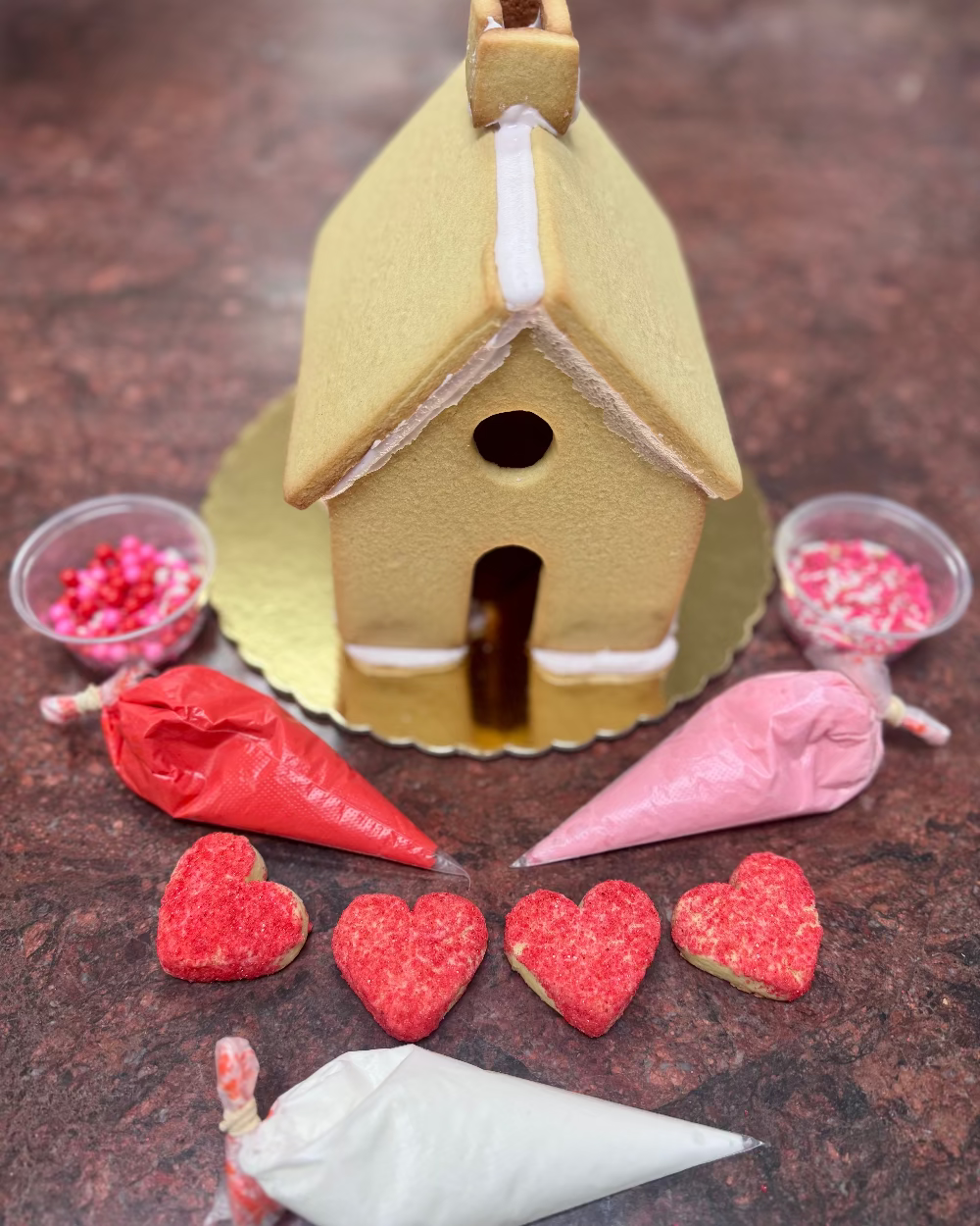 Decorative gingerbread house with icing and candy on a brown surface